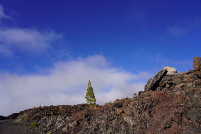 Low angle view of rocks against blue sky