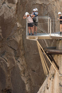 People standing on observation point by rock formation