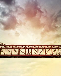 Low angle view of bridge against cloudy sky