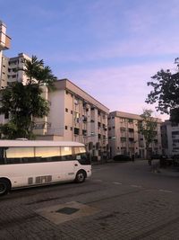 Street by buildings in city against sky