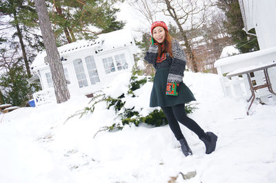 Portrait of smiling woman standing on snow