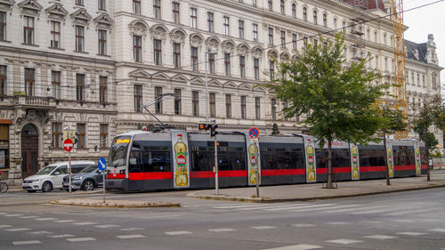 Vehicles on road by buildings in city