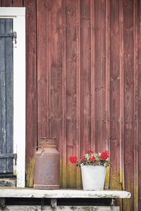 Flower pot and rusty container outside barn