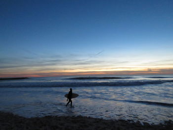 People on beach at sunset