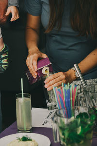 Midsection of couple holding drink