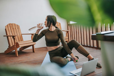 Full length of woman sitting on table