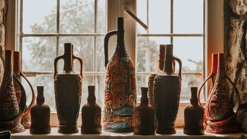 Close-up of earthenware on table by window