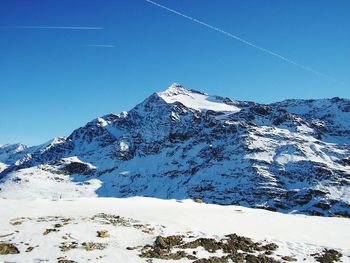 Scenic view of snowcapped mountains against clear blue sky