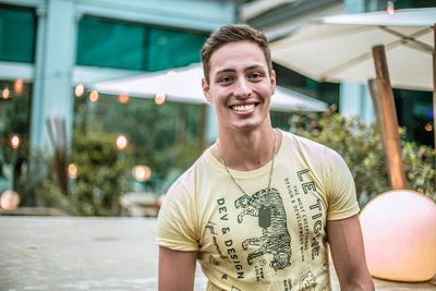 Portrait of happy young man standing outdoors