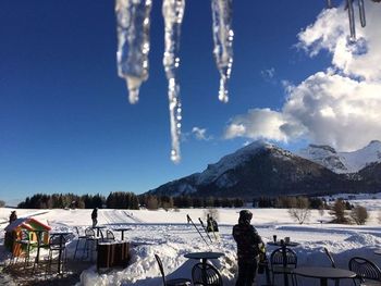 People standing on snow covered mountain against sky