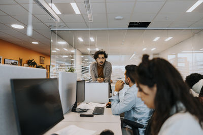 Male colleagues discussing strategy at desk in office