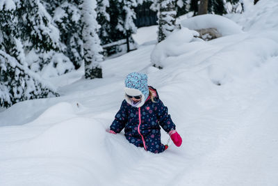 Rear view of woman skiing on snow covered field