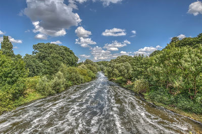 Road amidst trees against sky