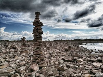 Stack of rocks on shore against sky
