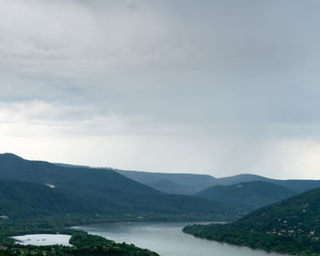 Scenic view of river and mountains against sky