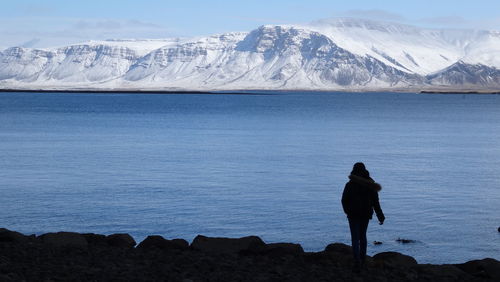 Scenic view of lake and snowcapped mountains against sky