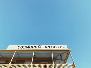 Low angle view of information sign against clear blue sky