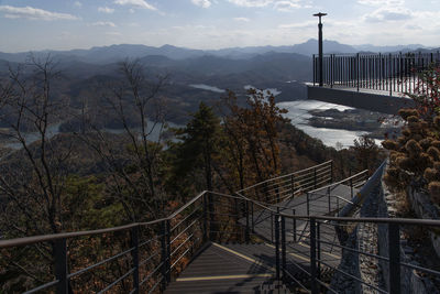 High angle view of footbridge over mountains against sky