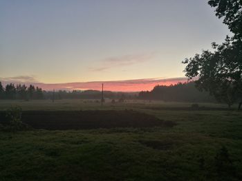 Scenic view of field against sky at sunset