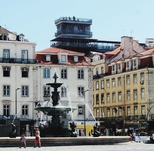 People on street against buildings in city