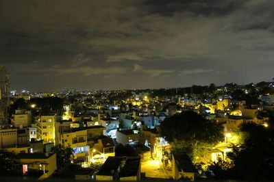 Illuminated cityscape against sky at night