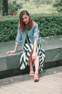 Portrait of a smiling young woman sitting outdoors