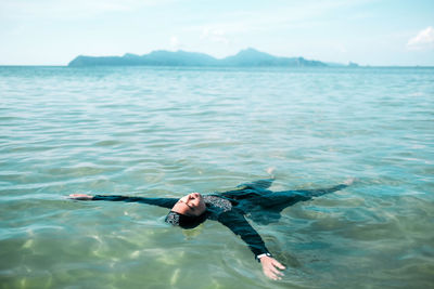 Carefree woman floating on lake