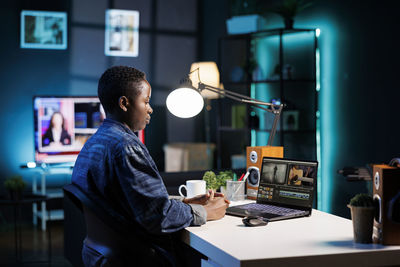 Side view of man using mobile phone while working at office