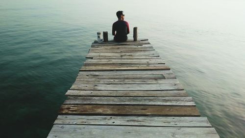 Rear view of man standing on pier