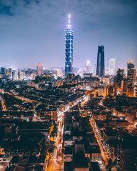 Illuminated cityscape against sky at night