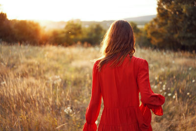 Rear view of woman standing on field