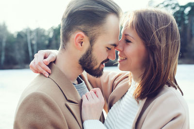 Smiling young couple romancing at riverbank