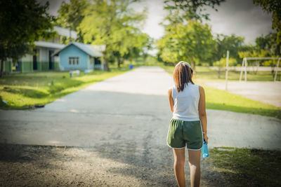 Woman walking in the park with bottle water in her hand health care concept.