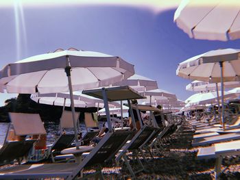 Panoramic view of lounge chairs and parasols against sky