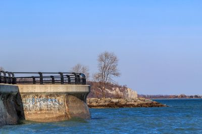 Built structure by sea against clear sky