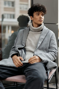 Portrait of young woman sitting on chair