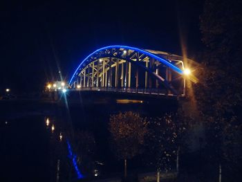 Illuminated bridge against sky at night