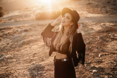 Woman wearing hat standing on land