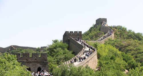 People at historical building against clear sky