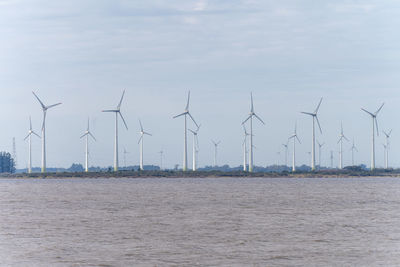 Wind turbines on land against sky