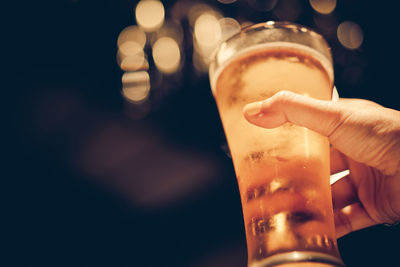 Close-up of hand holding beer glass