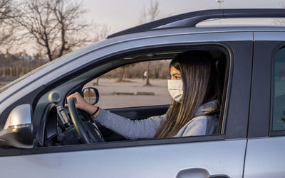 Portrait of woman sitting by car window