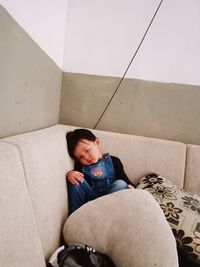 Boy sitting on sofa at home