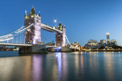 Illuminated tower bridge against sky at dusk