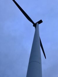 Low angle view of wind turbine against blue sky