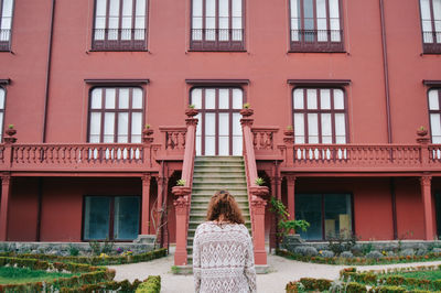 Rear view of woman standing against building