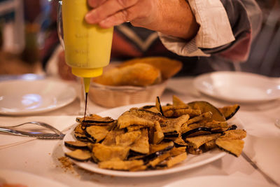 Midsection of man preparing food in plate on table