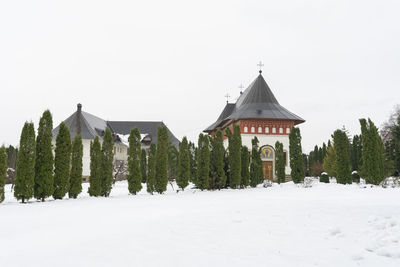 Panoramic shot of trees on snow covered land against sky