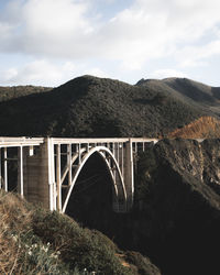 Arch bridge on mountain against sky
