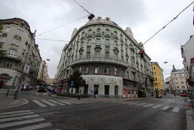 Buildings in city against cloudy sky